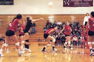 Middle blocker Emily Boerger ducks a dig by teammate Jadelyn Thompson in their 3-0 win over Arlington.