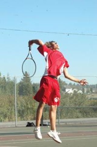 Junior Christopher Wall  reaches high in the air for a serve Friday