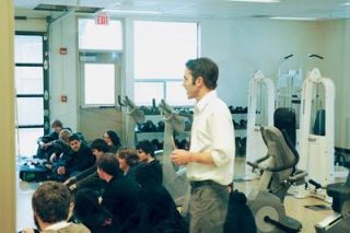 Instructor Tyler Stevenson talks to some of his students about the new fitness room equipment available to them. In the leased space the district formerly used for the A & T school