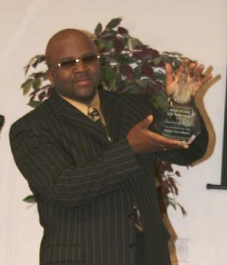 Pastor Jason Martin shows off the Church of the Week Award for the Jesus Is Lord Life Tabernacle