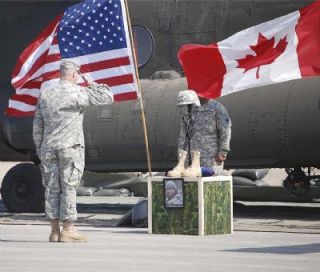 An unidentified soldier salutes a memorial to Specialist Joseph M. Cerfus during a service held last week. A Marysville resident and Army Reservist