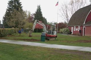 A worker installs irrigation pipes next to the red barn in Jennings Memorial Park on April 26. Automated underground sprinklers were installed in the ball fields and under turf near the red barn.