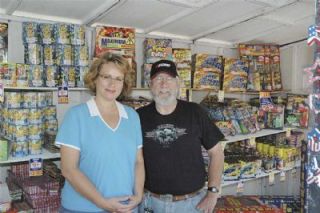 Ginger Olsoy and Jake Englet were staffing the Kiwanis sponsored fireworks booth in the lot of the State Avenue Safeway. Englet believes that ultimately sales will be affected by new city fireworks rules.