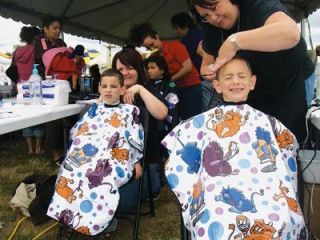 Malu and Keli Rynders get free haircuts for the start of the school year at the Summer Jubilee at Asbery Field on Aug. 12. The Lake Stevens brothers were smiling one moment  then had to put on their games faces for the camera. They were at the huge event getting free school supplies