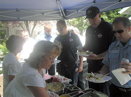 Merrill Gardens food service managers serve burgers to Marysville Fire District Fire Marshal Tom Maloney