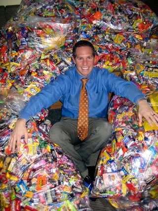 Marysville orthodontist Dr. Jason Bourne poses with some of the candy collected during a recent Halloween Candy Buy-Back. Dr. Bourne pays $4 for each pound of candy brought to his offices - $2 goes to the child who brings in the candy and $2 is donated to local the Boys and Girls Club and YMCA. The candy is sent to troops serving overseas.