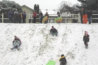 Adults and children alike ascend to the top of the slippery hill on the east side of Jennings Park Dec. 17