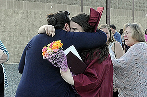 Graduates hug family after the graduation at Lakewood High School.