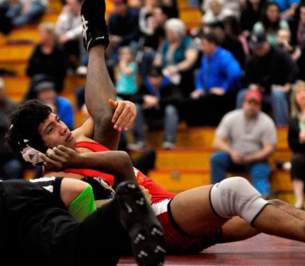 Christian Mendoza (130 pounds) is on the verge of pinning opponent Athan Taisague. Mendoza’s pin was the first of seven M-P pins against Oak Harbor.