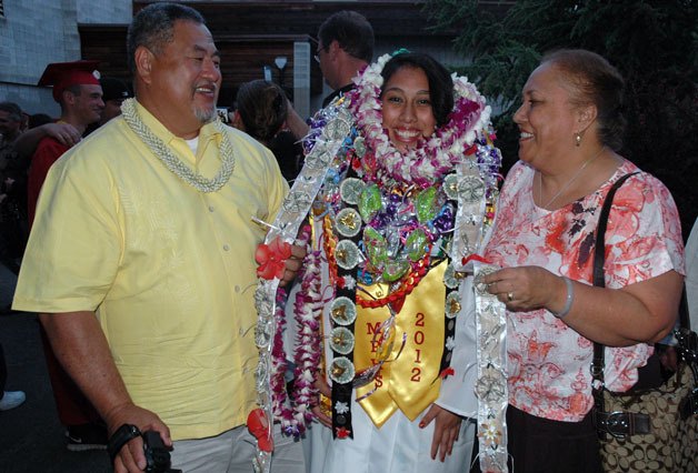 Marysville-Pilchuck High School Class of 2012 graduate Jesaikah Tagi receives multiple leis of dollar bills and candy from her father Fia