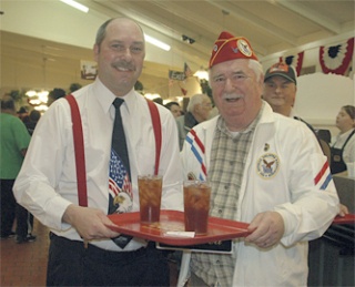 Golden Corral owner Mike Kossak takes Ken Reed's tray as he escorts the retired veteran to his table.