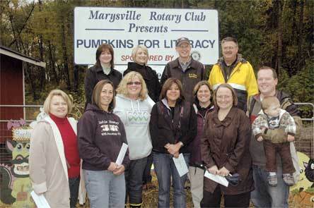 Representatives of the Marysville School District held their checks from “Pumpkins for Literacy” at the Smokey Point Plant Farm Oct. 31. From left