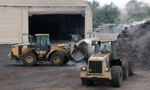 Cedar Grove workers at Smith Island move compost after it’s received a thickening agent.