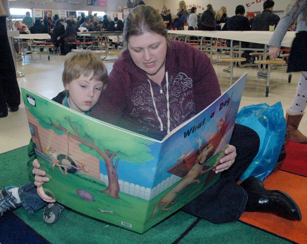 Graham and Becky Larson read from a selection of oversized picture-books that Graham will be treated to when he starts kindergarten this coming school year.