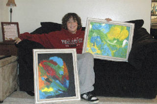 M-P freshman Eli Flippin poses with two of his larger works in his Marysville home. Flippin’s work will be on display and for sale at an art show Nov. 21