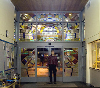 Camano Island glass artist Jack Archibald recently installed his latest public art project at the Marysville Library with the help of Robert Ansell who also assisted in the fabrication.  The 12-foot by 12-foot glass mural titled “Dewey Digital” surrounds the entryway to the library with a design meant to create a dynamic portal into the virtual stacks of today’s information world. The artist