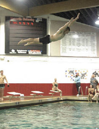 Tomahawk linebacker Mike Stone belly flops off the diving board. The football team and girls swim team got together to help raise money for a former football player diagnosed with cancer.