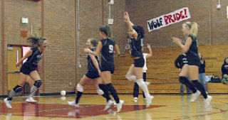 The team rushes to congratulate senior Chelsey Graber as she delivers the game-winning point on an ace