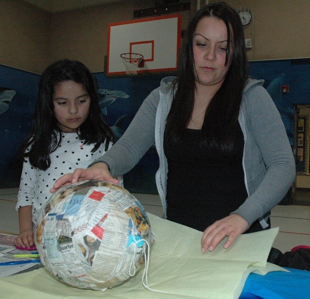 Shoultes Elementary second-grader Ashley Ortiz looks on as her mother Lucia helps her assemble a piñata after school on Feb. 19.