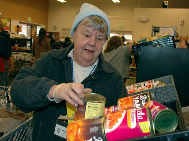 Karen Strand assists a Marysville Community Food Bank client in picking out items for a Thanksgiving food basket on Nov. 18.