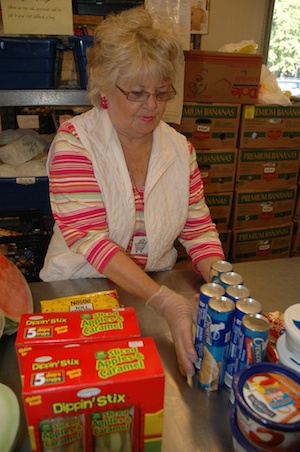 Volunteer Bobbi Bryant sets out crescent rolls for clients at the Marysville Community Food Bank.