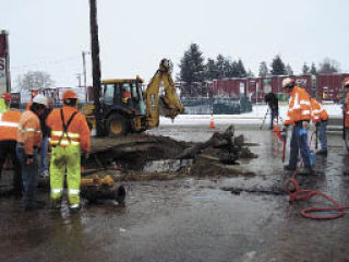 City crews work to repair a fire hydrant and water main break on Cedar Avenue Dec. 17 after they were hit by a car and damaged.