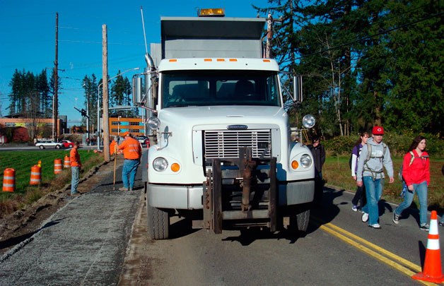 Marysville Getchell High School students walk past the work being done by city street crews to install a walkway along 83rd Avenue.