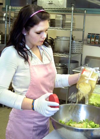 Marti Gannon prepares a bowl of Caesar salad for patrons of the School House Cafe on the Totem Middle School campus Feb. 17.