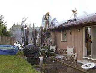 Emergency crews had to rip open the roof of this 67th Avenue home when flames reached the attic space.