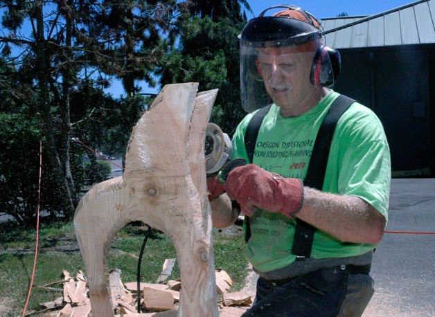 Seattle chainsaw carver Ken Ballenger sculpts a hummingbird statue at the Marysville YMCA’s Summer Art Fair on July 27.