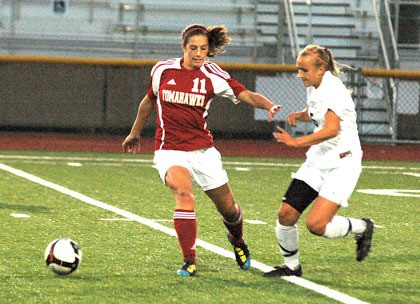 M-P sophomore midfielder Becca Lentz keeps a Monroe defender at arm’s length.