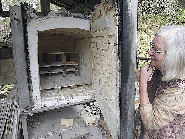 Gayle Persis looks inside a kiln she uses to maker her pottery