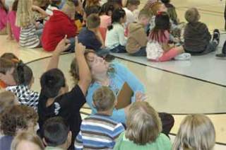 Grove Elementary third grade teacher Denise Scofield looks up as one of her students points to the basketball hoop. The hoop later made a dramatic entrance as school administrators showed off some of the new school's features.