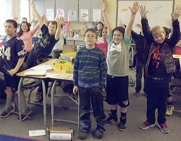 Students in Beth Varousek's fourth-grade class raise their hands to the song 'Dynamite' during their 'The Leader in Me' segment of class.