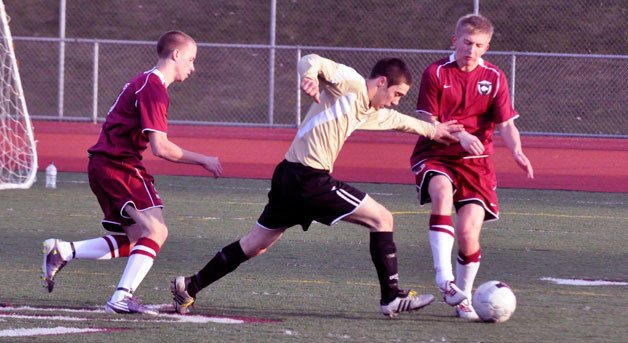 Caleb Graves is pressured by two Cedarcrest defenders.