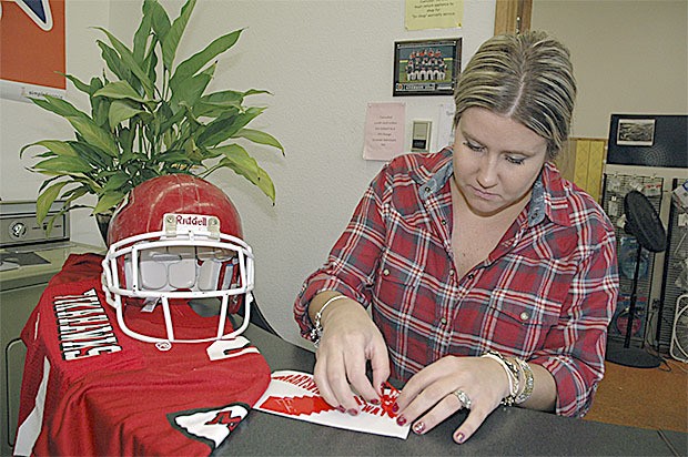 Christen Dickerson works on one of the decals she is selling to raise money for a memorial for the victims of the shooting at Marysville Pilchuck High School. She is an alum of M-P