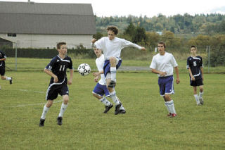 Grace soccer player Ben Hackbarth achieves liftoff as he fights for the ball at midfield.