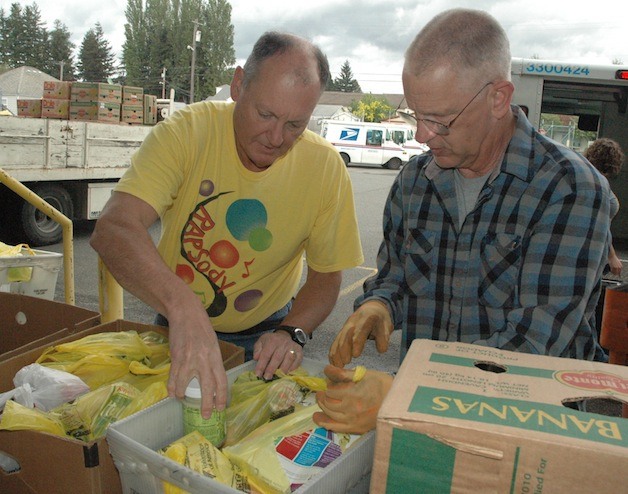 George Donaldson and Dennis Trautman sort donations at the Marysville Post Office during the May 10 Letter Carriers’ Food Drive.