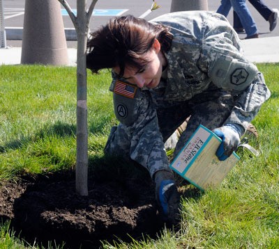 U.S. Army Sgt. 1st Class Adrian Bennett with the 364th Sustainment Command fertilizes newly planted trees during the unit’s commemoration of Earth Day in Marysville on April 22.