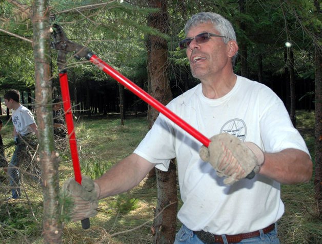 Lynn Francis trims the branches of trees at the Doleshel Tree Farm Park to provide better safety and visibility during this year’s National Day of Service and Remembrance on Sept. 15.