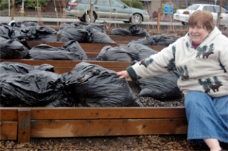 Bea Randall points out a new composting system invented by Leilani Wallace. Last fall’s leaves