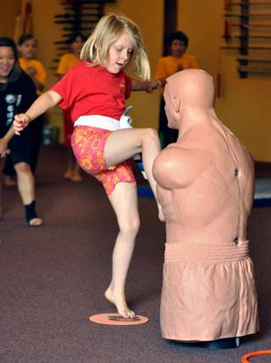 Mercedes Benson kicks a dummy during a Kung Fu Camp Olympics-themed obstacle course at Kung Fu Northwest on Aug. 9.