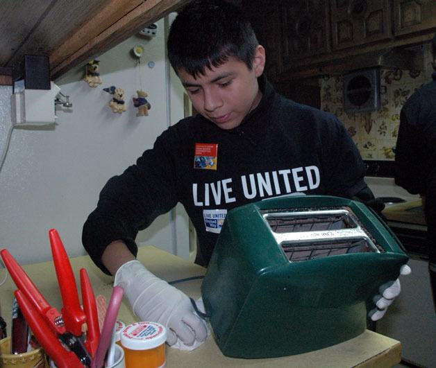 Cedarcrest Middle School student Johvanny Alvarez cleans off Marysville resident Don Gillette’s kitchen countertops as part of Snohomish County’s MLK Day of Service on Jan. 21.