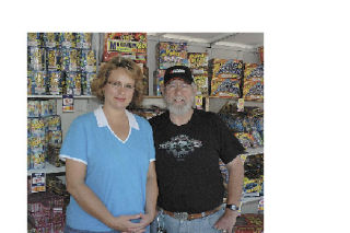 Ginger Olsoy and Jake Englet were staffing the Kiwanis sponsored fireworks booth in the lot of the State Avenue Safeway. Englet believes that ultimately sales will be affected by new city fireworks rules.