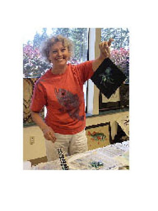 Helen Saunders demonstrates fish printing at the Arlington Arts Council’s July 8 meeting and she will be exhibiting her prints and other multimedia work at Art by the Bay