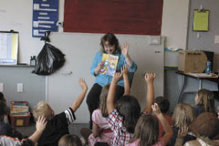 Third-grade teacher Denise Scofield raises her hand with her students as she asks them whether they were nervous about coming to school for the first day.