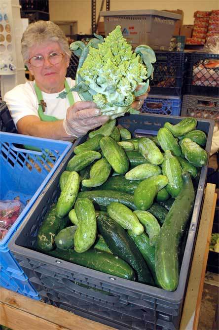 Marysville Community Food Bank volunteer JoAnn Sewell holds up a cross between a broccoli and a cauliflower