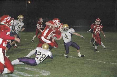 Marysville-Pilchuck quarterback Zack Hanson runs through an Oak Harbor tackler during the first half of the Tamahawks’ 49-28 win.