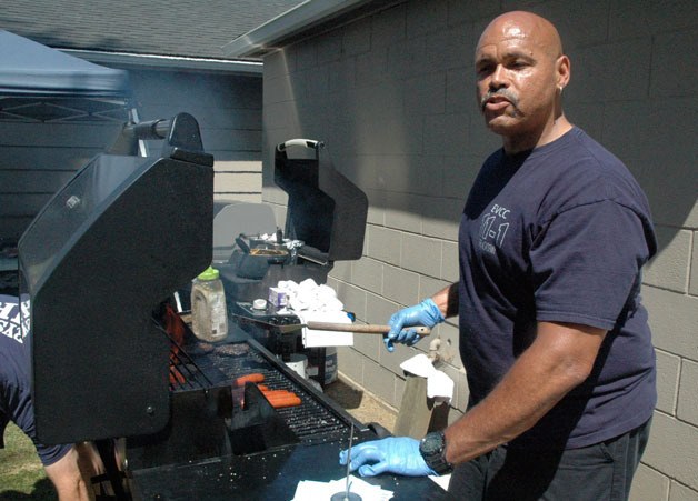 Marysville Fire District paramedic Russell Colmore cooks up hot dogs and hamburgers for attendees of the Dalmatian Drive’s family fun day on July 20.