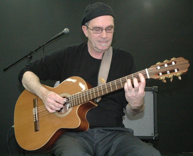 Michael Gotz plays his acoustic guitar at the Marysville Arts Coalition’s ‘It’s Raining Art’ event on April 26.